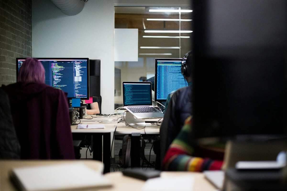 Developers coding in a modern office workspace.